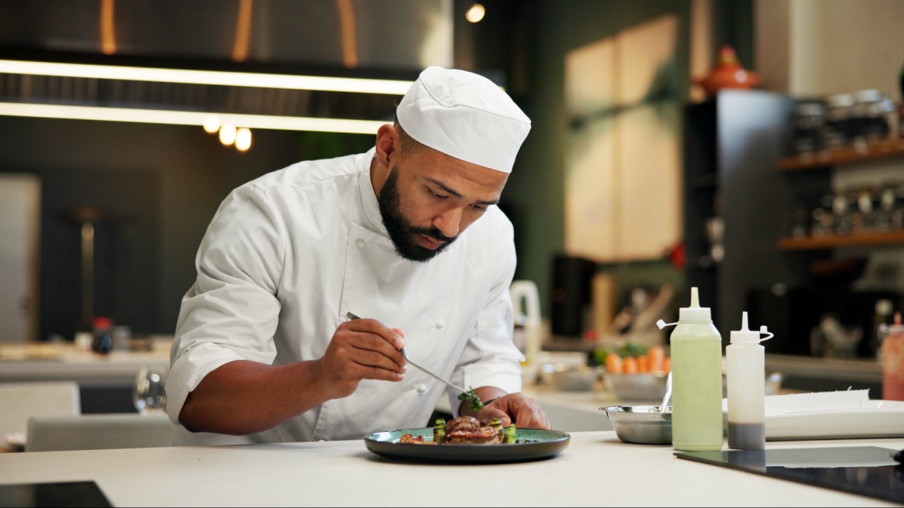 Man, chef and serious with food in kitchen at restaurant for fine dining, meal and creativity. Male employee, professional and cooker with pride for culinarily, hospitality and catering service