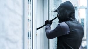 Man, criminal and crowbar for house crime, home invasion and breaking entering attempt with tool. Apartment, robbery and burglary or trespassing on property, security breach and owners safety risk
