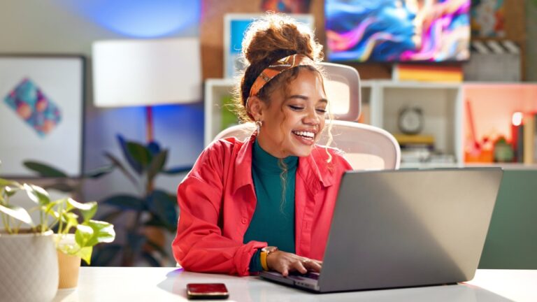 Woman, laptop and happy for business in home office for digital agency, content creation and email. Social media manager, technology and smile for influencer blog, communication or trendy funny video