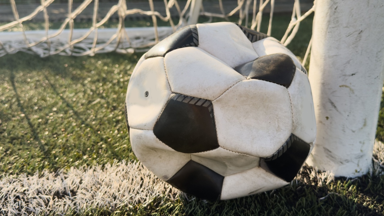 Deflated soccer ball on grass.
