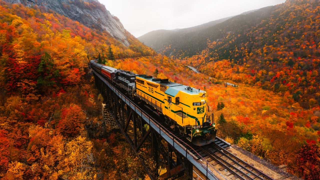 North Conway, New Hampshire - October 14, 2021: Famous Conway Train Touring New England Scenic Ride on Tracks Fall Foliage. Colorful Forest Trees