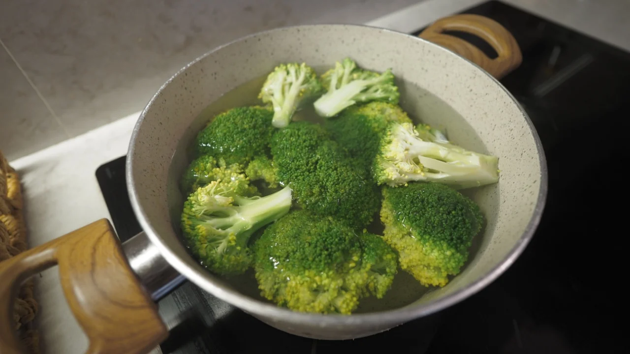 Broccoli boiling in pot on stovetop during evening cooking session