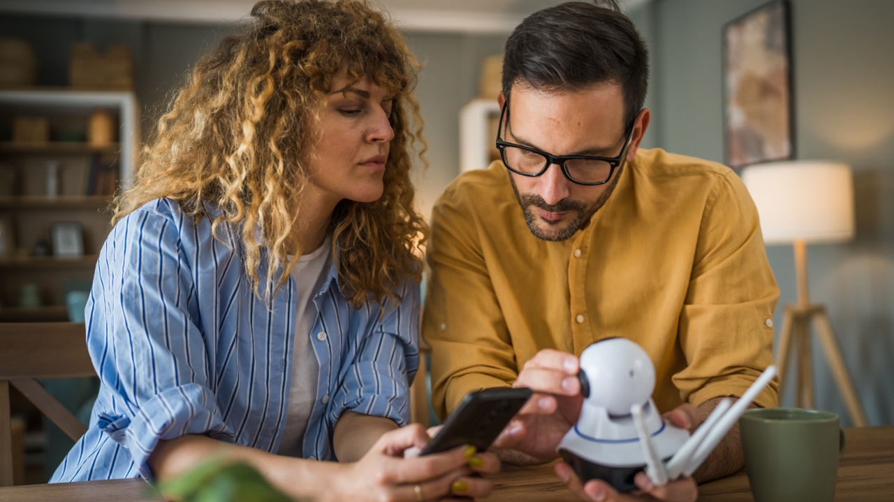 Couple adult caucasian man and woman at home connecting setup and install cctv security video surveillance camera monitoring system