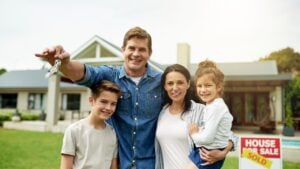 Portrait, happy and family with keys of new home for real estate success, investment and homeowner. Smile, parents and kids with property purchase, approved mortgage and achievement for secure future