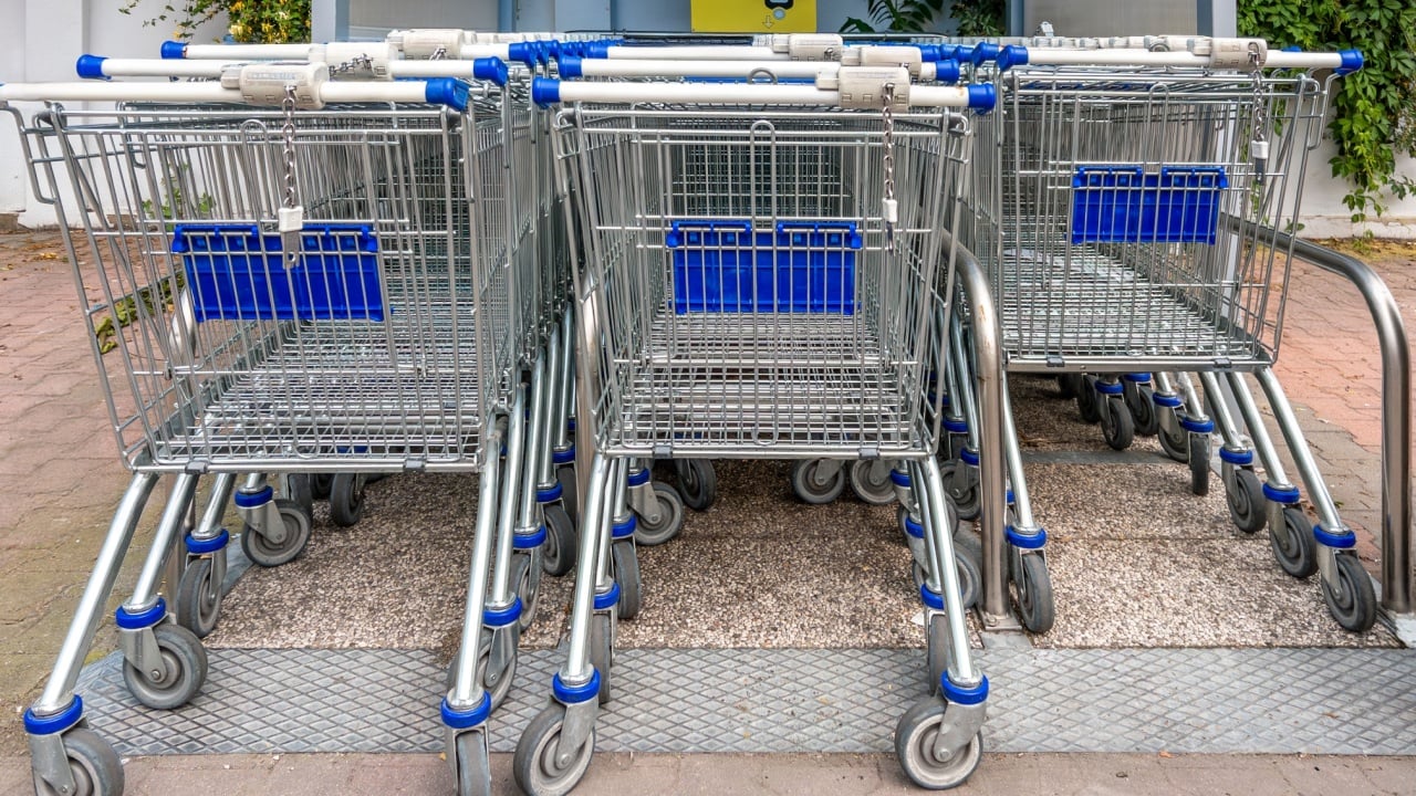 Empty shopping carts piled up in rows in the storage area outside the supermarket.