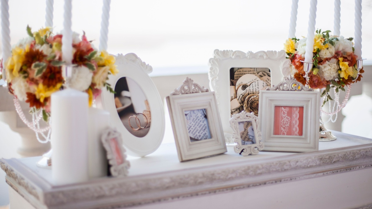 khabarovsk, russia, 20.10.2013 Decorative wedding table with candles, flowers, and picture frames displaying rings and lace for romantic celebration.