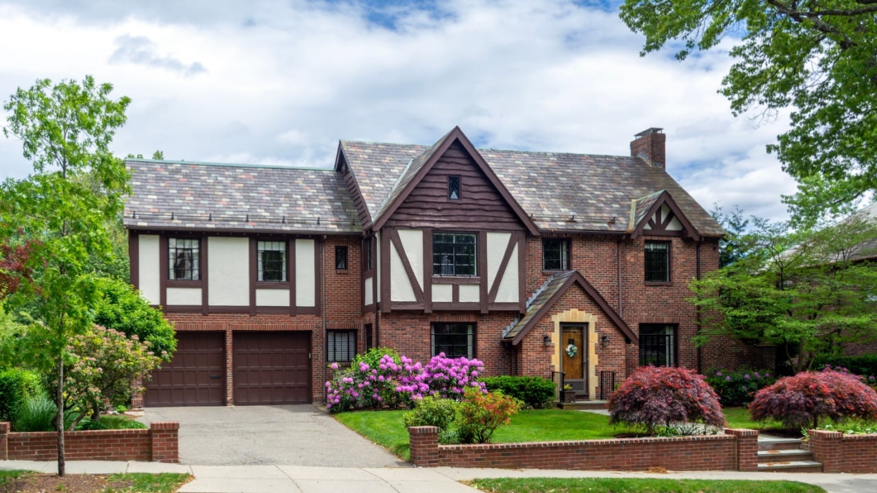 Elegant Tudor Revival family house with brick facade and blooming garden in Brookline, Massachusetts, USA