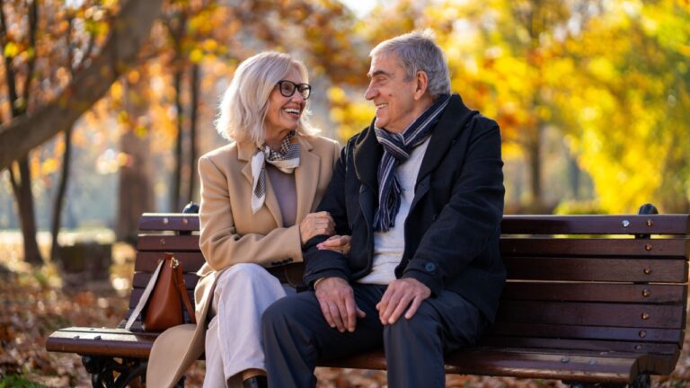 Happy senior couple enjoying a beautiful autumn day in the park together