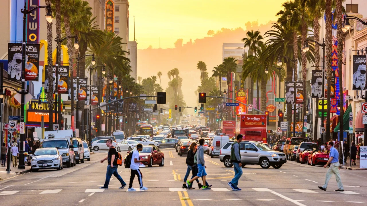 LOS ANGELES, CALIFORNIA - MARCH 1, 2016: Traffic and pedestrians on Hollywood Boulevard at dusk. The theater district is famous tourist attraction.