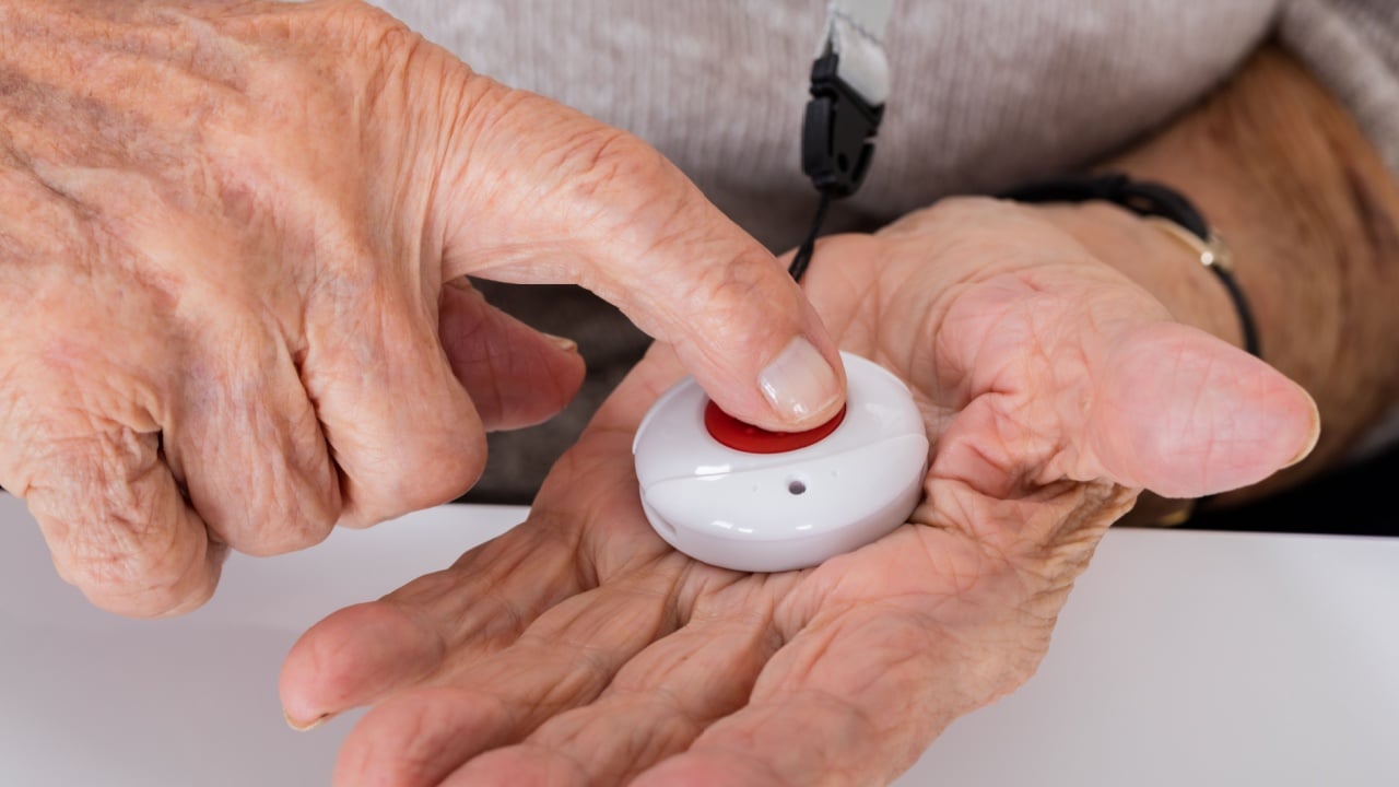Close-up Of Senior Woman Pressing Alarm Button For Emergency