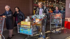 Fairfax, USA - December 3, 2016: People with shopping carts filled with groceries walking out of Costco store in Virginia
