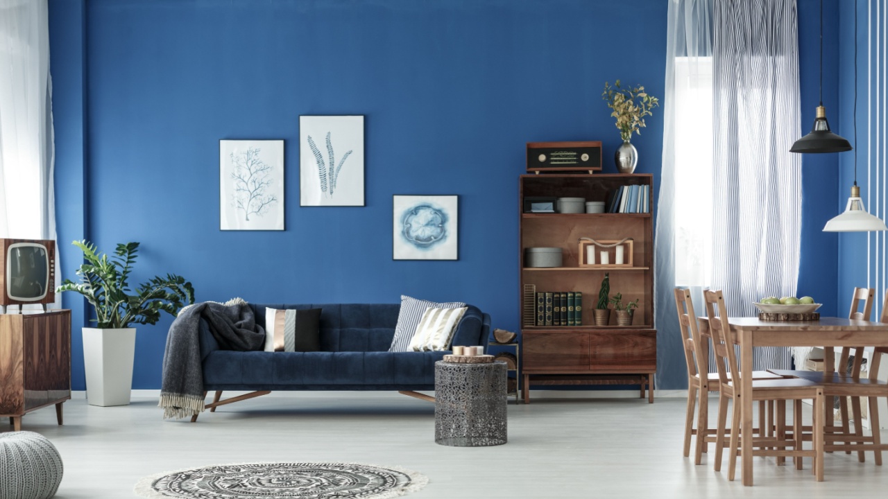 Spacious retro style living room with blue wall and wooden floor