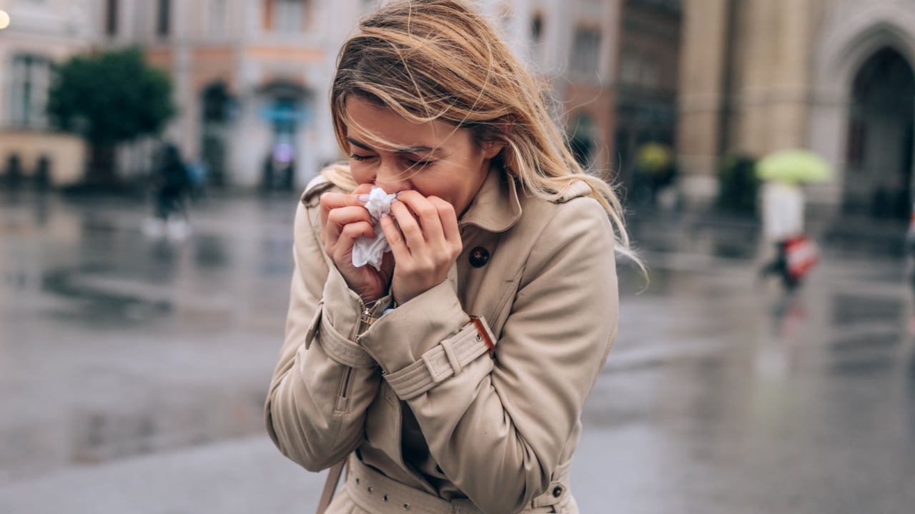 A beautiful young woman blowing her nose in public.