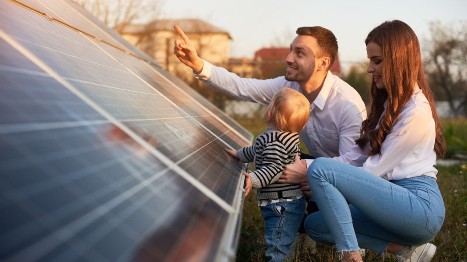 Side view shot of a young modern family with a little baby boy getting acquainted with solar panel on a sunny day, green alternative energy concept (1)