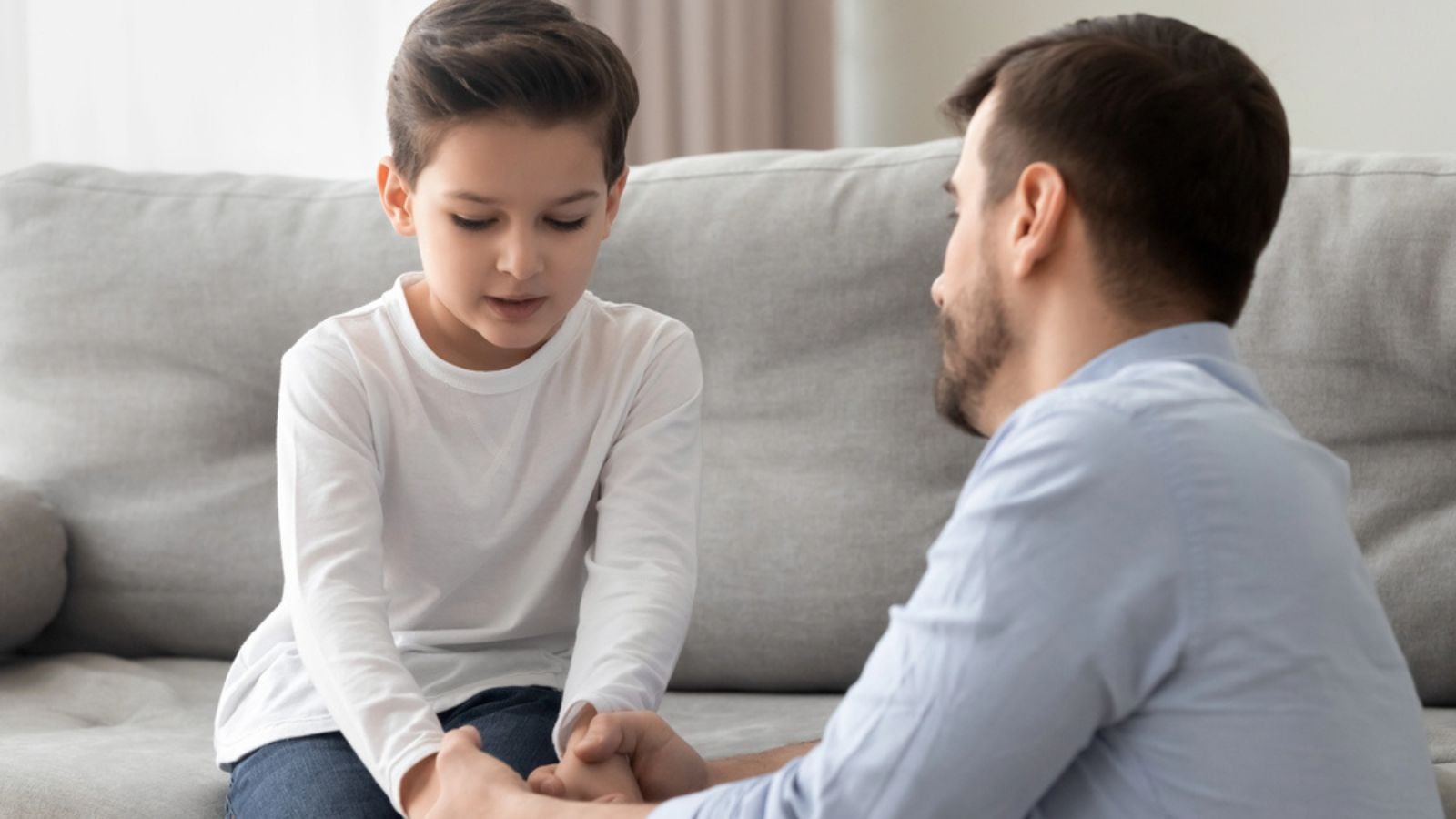 Worried father comforting upset kid son helping with problem