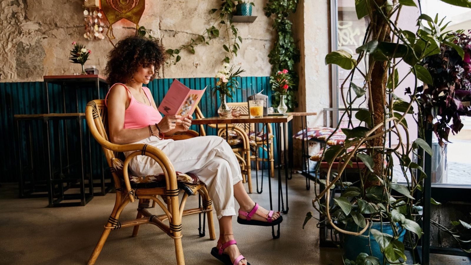 young woman traveler tourist living abroad sitting in europe cafe reading