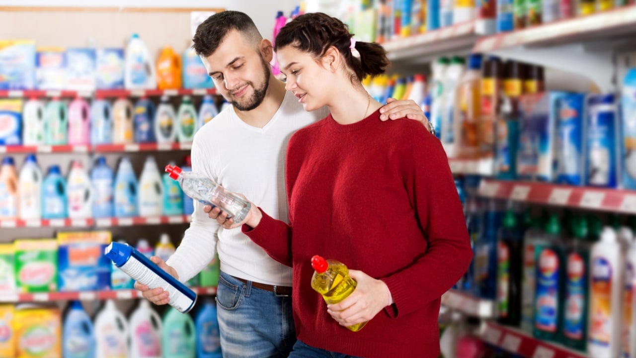 Positive couple buying detergents for house in the shopping mall