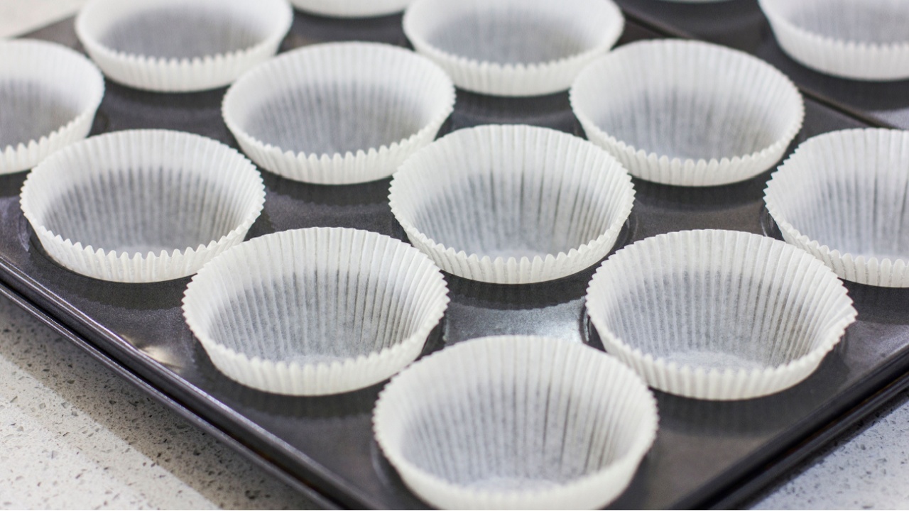 Empty paper forms for muffins and cupcakes in a metal tray