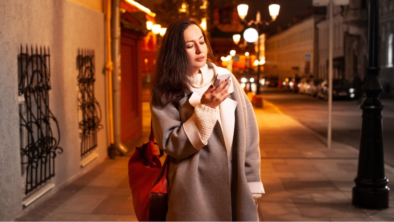 The girl walks around the evening city with lighted lanterns in the autumn