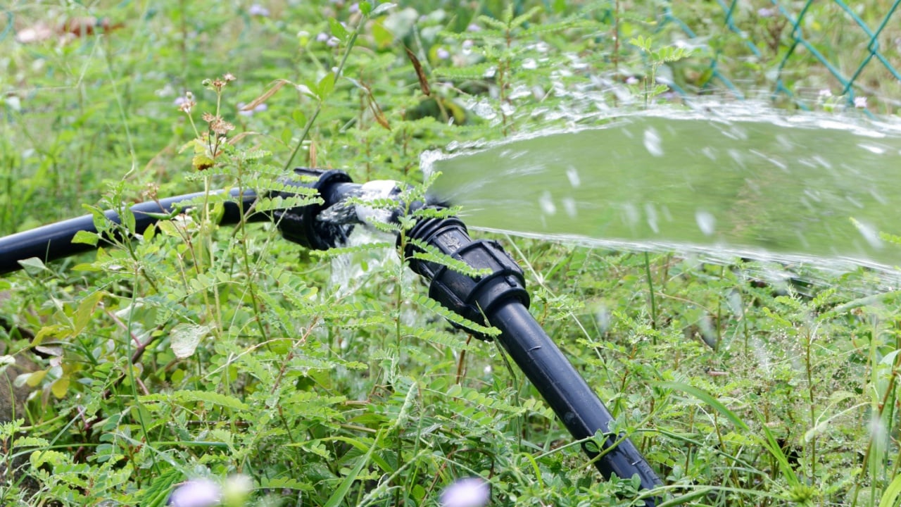 A Water pipe break, leaking from hole in a hose connection joint of plastic pipes Water supply system, selective focus