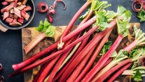 top view of fresh ripe healthy rhubarb stalks on wooden board