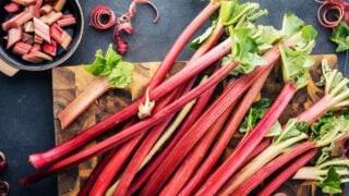 top view of fresh ripe healthy rhubarb stalks on wooden board