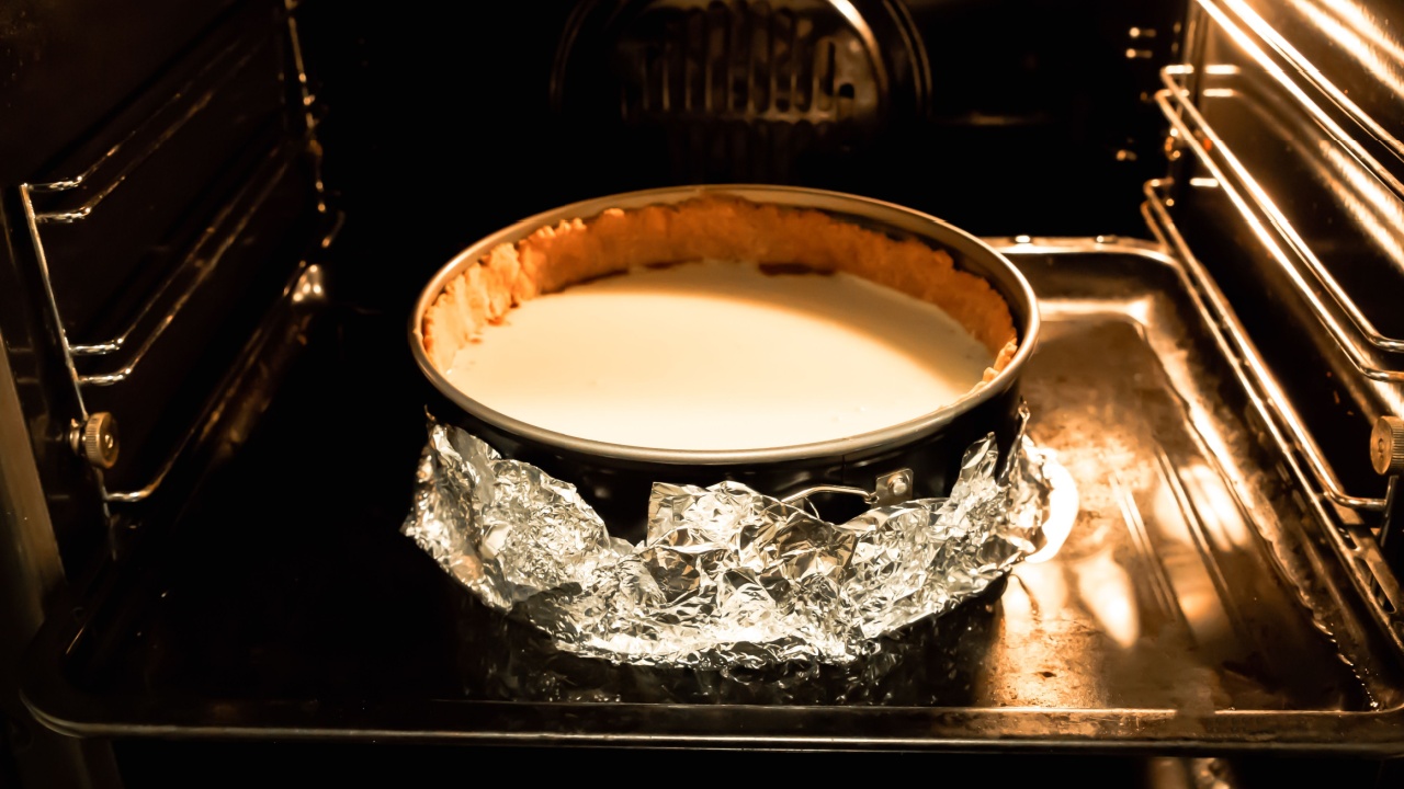 Cheesecake in the oven on water bath. Springform pan in foil. Baking process. Homemade desserts. Tasty pastry.