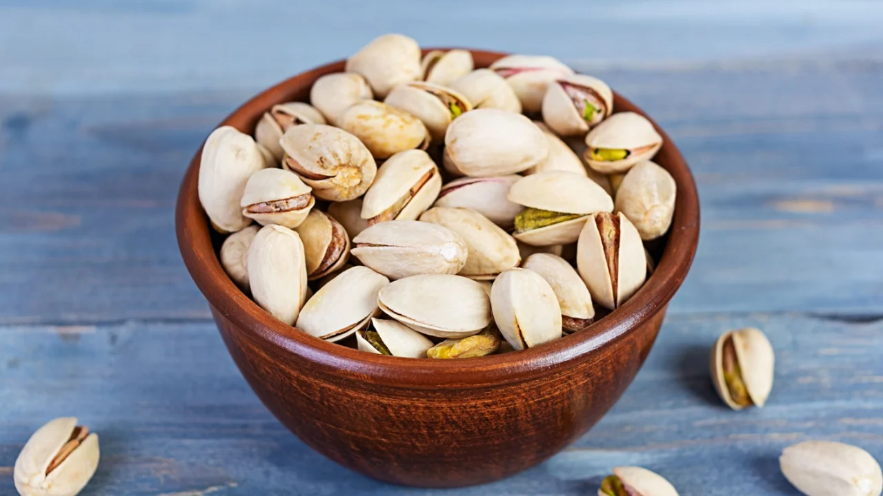 Pistachio nuts on wooden background. Roasted salted pistachios.