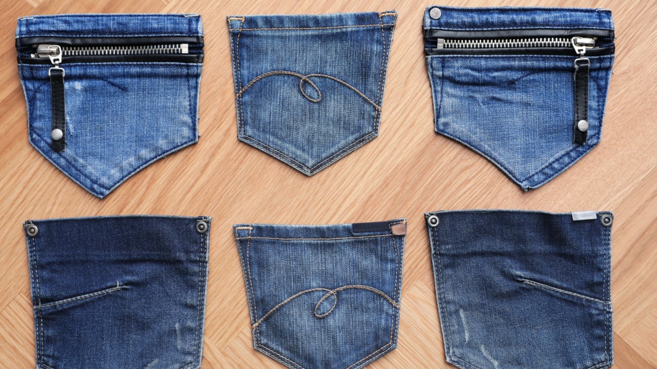 Flat lay composition with jeans pockets on table