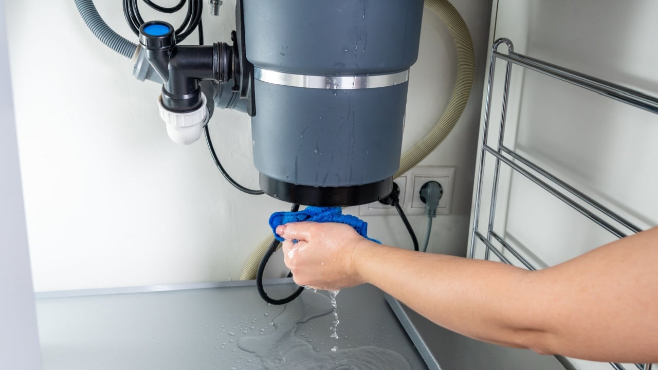 Waste disposal leak under a sink, broken garbage chopper