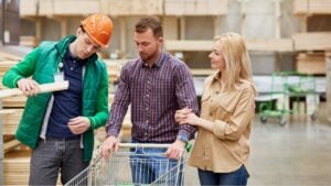 consultant of market enjoy being useful for customers, man help people with choice, give advice and have talk about products in assortment, wooden board in the background. in market