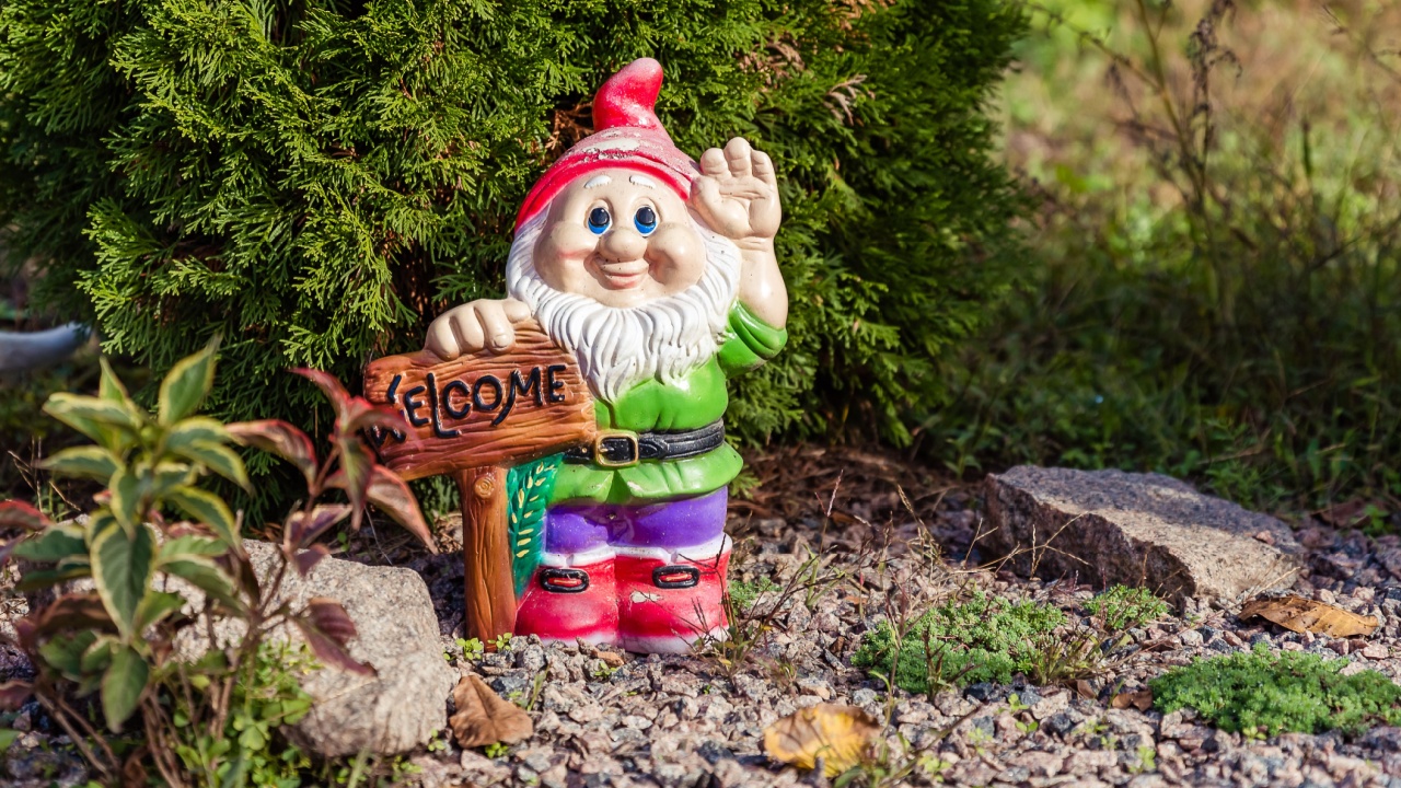 Figurine of a garden gnome in the garden with a sign.