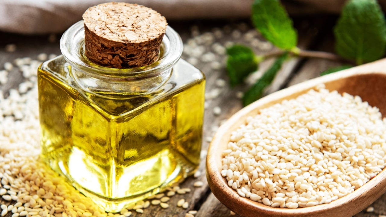 Healthy food and drink concept. Sesame oil and seeds on a rustic table.