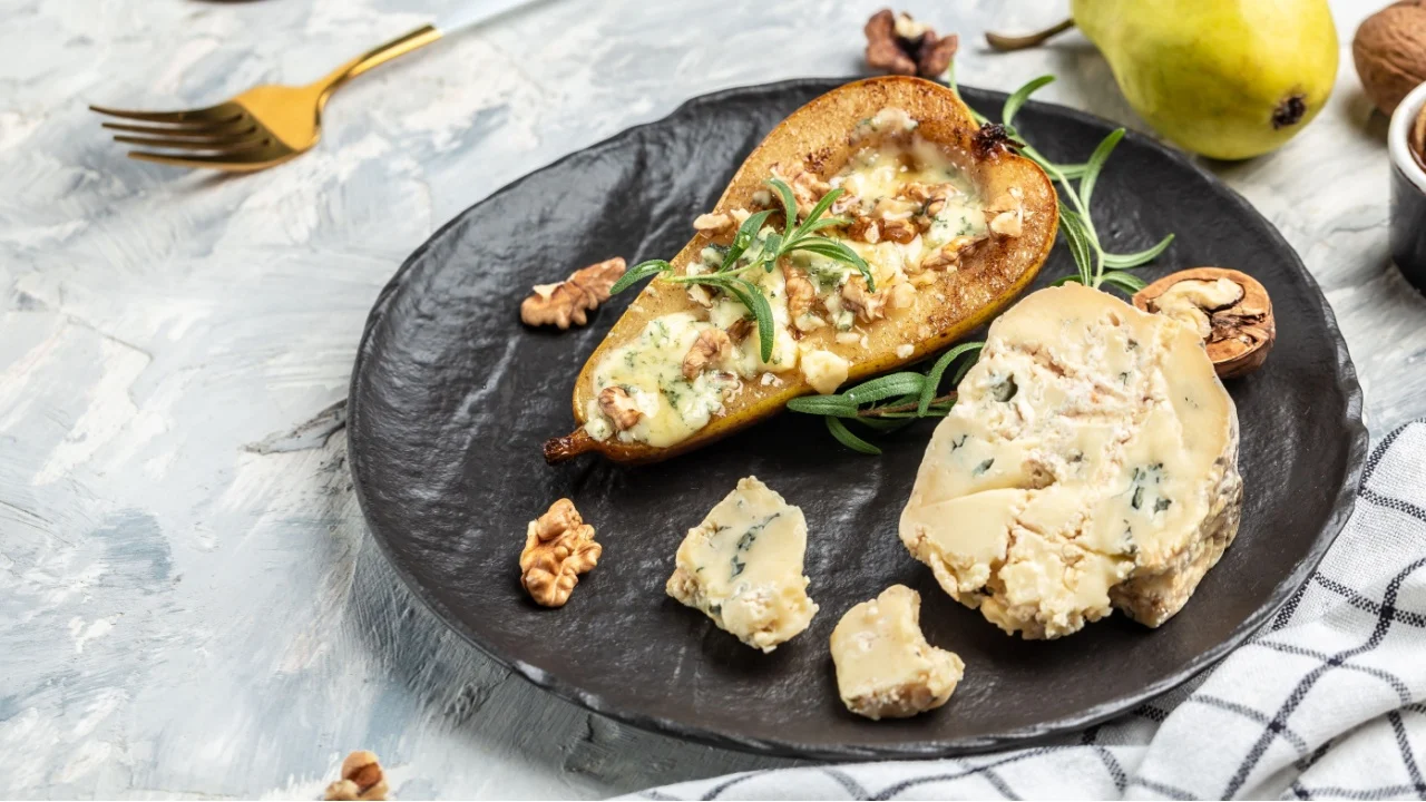 Blue cheese with pears and walnuts. Appetizer with pear baked with dorblu, gorgonzola, roquefort. Delicious balanced food concept.
