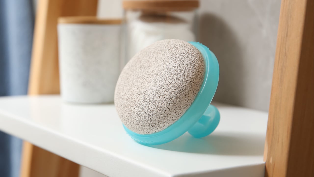 Pumice stone on white shelf in bathroom,