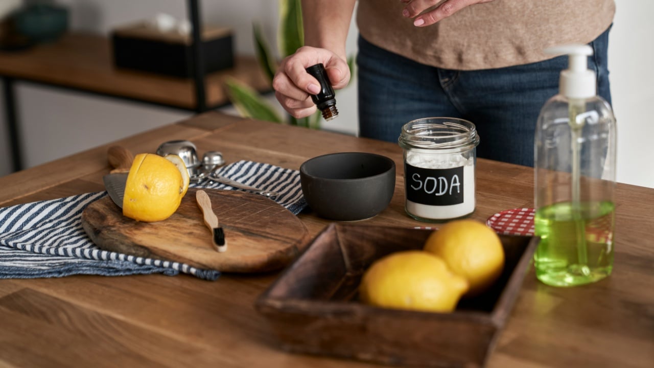 Unrecognizable person adding essential oil to the bowl with DIY cleaning product