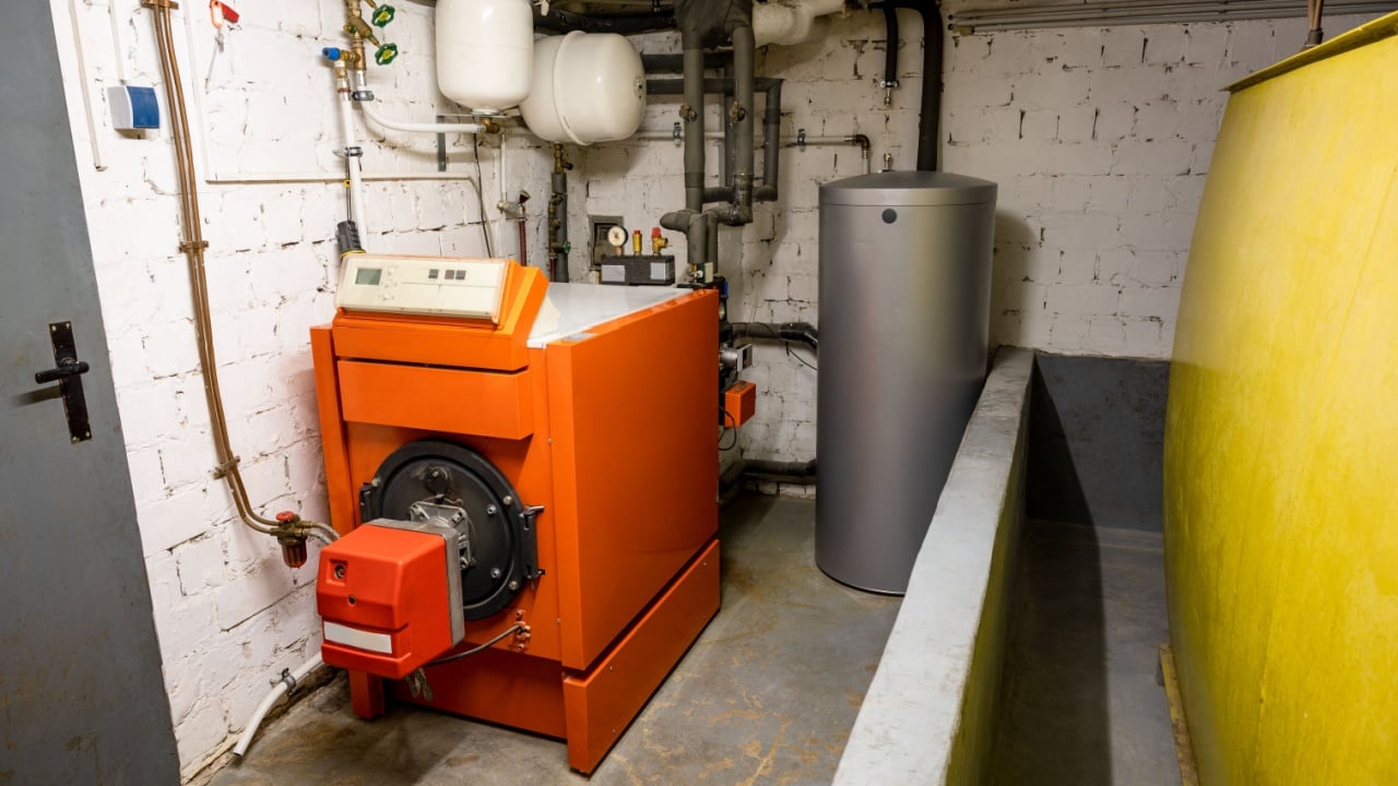 Old oil heating system with oil tank and hot water tank in the basement of a family house - heating with fossil fuels
