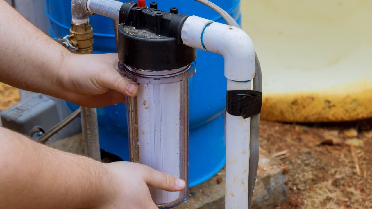 Replace replaceable filters for cleaning water near home by professional workers performing maintenance work replacing replaceable filters in outside parts of house