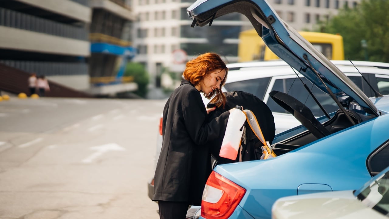 A woman puts things in the car