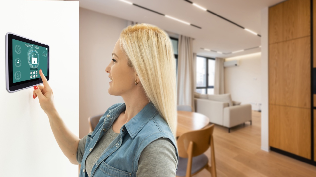 Side view pleasant young woman using smart home system or activating modern alarm system before leaving apartment. Happy lady turning off easy security technology, when returning house or flat