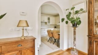 a living room with a dining table and an archway leading to the kitchen in the door is open on the right side
