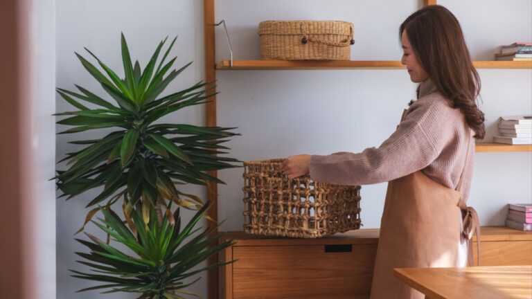 Portrait image of a woman holding a wooden basket while cleaning house