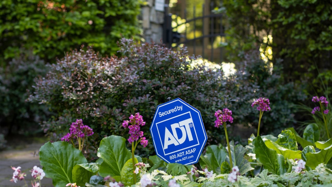 Lake Oswego, OR, USA - May 21, 2022: Secured by ADT sign is seen outside a gated property. ADT, Inc. is a security company that provides residential and small business electronic security services.