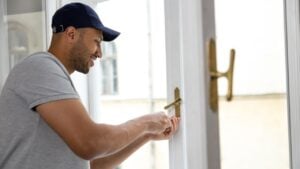 Adult man fixing window at home doing work about the house.