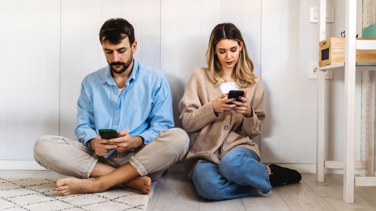 Couple addicted to smartphones ignoring each other at home. Relationship problems