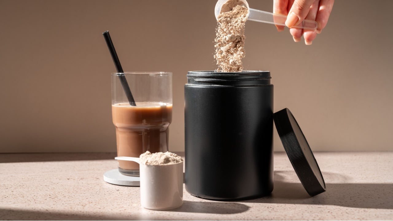 Protein shake and chocolate protein powder in a scoop, food supplement