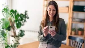 Successful confident woman entrepreneur with mobile phone indoors.