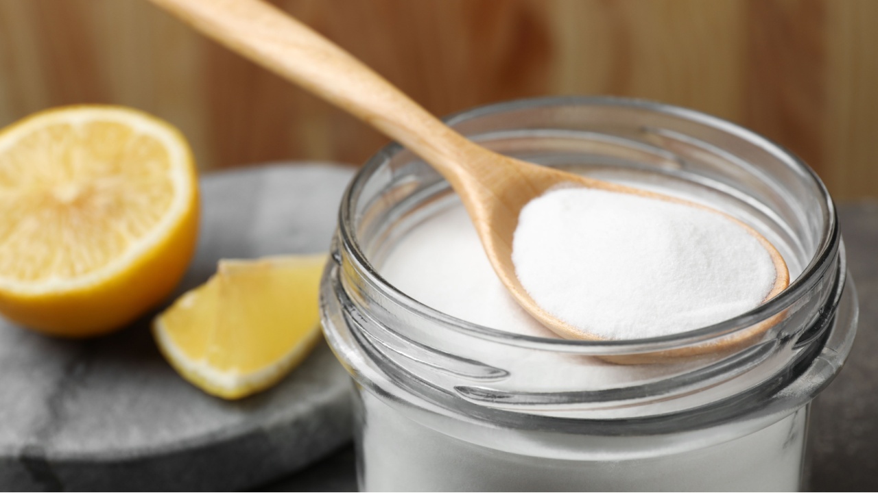 Baking soda, spoon and lemon on table, closeup