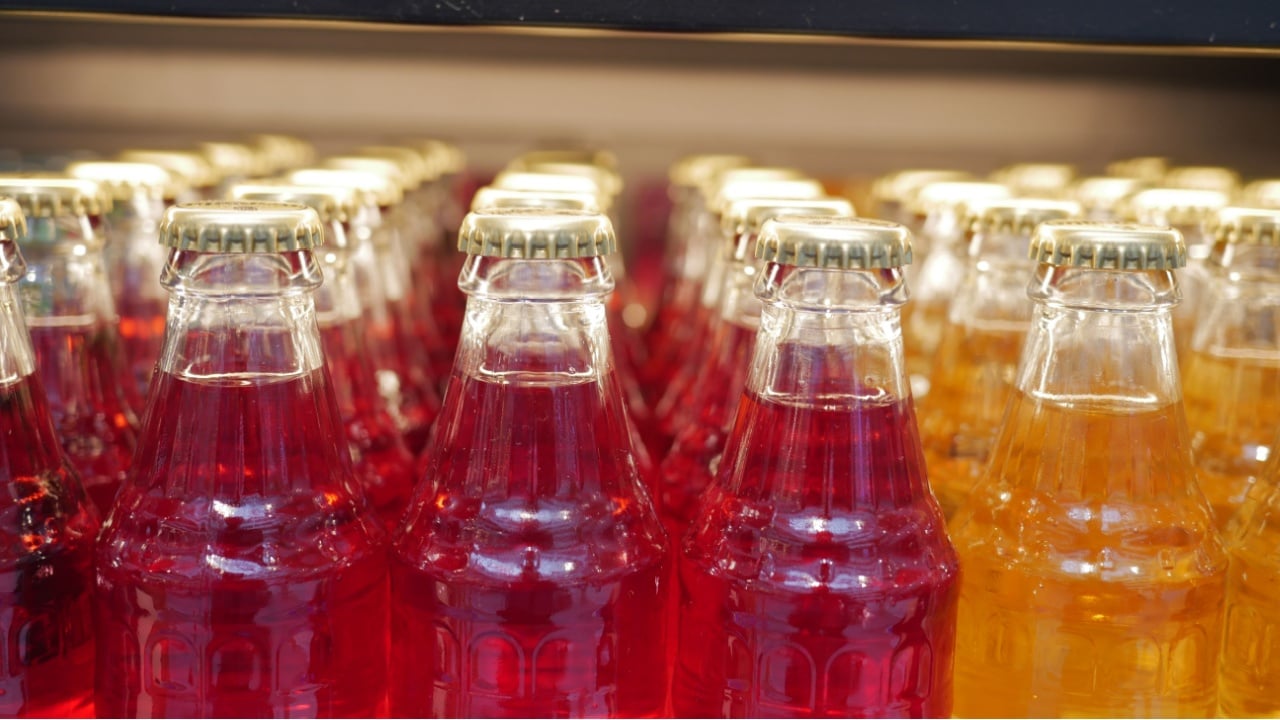 Colorful glass bottles filled with soft drinks displayed prominently