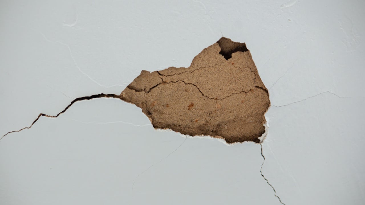 Wall crack exposing inner plaster.